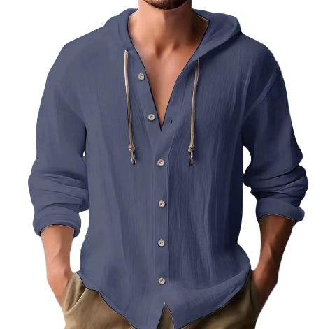 Man wearing a blue button-up shirt with a beach background
