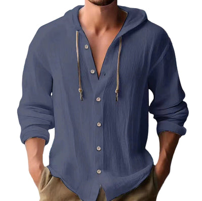 Man wearing a blue button-up shirt with a beach background